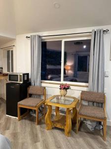 a living room with a table and two chairs and a window at Cabin in the woods @ Cultus Lake in Chilliwack