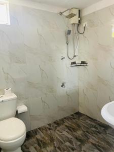 een badkamer met een douche, een toilet en een wastafel bij Star Canal Cottage in Negombo