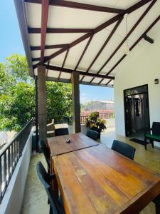 einen Holztisch und Stühle auf einem Balkon mit einem Tisch in der Unterkunft Star Canal Cottage in Negombo