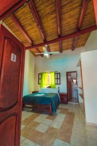 1 dormitorio con cama y techo de madera en Hosteria Puerta de Corral Quemado en Las Juntas