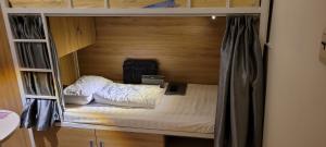 Zimmer mit einem Etagenbett aus Holz in der Unterkunft REDHOME DORM in Ho-Chi-Minh-Stadt