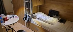 a small bed in a room with a table at REDHOME DORM in Ho Chi Minh City