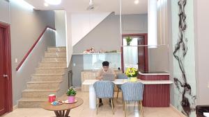 a person sitting at a table with a laptop at REDHOME DORM in Ho Chi Minh City +6 photos