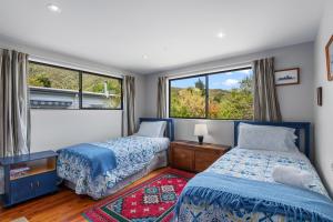 a bedroom with two beds and a window at Waimarama Hideaway - Waikawa Holiday Home in Waikawa