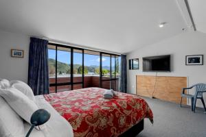 a bedroom with a bed and a large window at Waimarama Hideaway - Waikawa Holiday Home in Waikawa