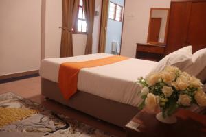 a bedroom with a bed with flowers on a table at Bunga Raya Resort Parit Buntar in Parit Buntar +26 photos