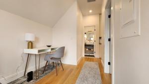 Habitación blanca con escritorio y silla en Ultra Convenient East Boston Luxury Condo, en Boston