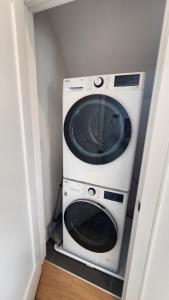 a washer and dryer in a corner of a room at Ultra Convenient East Boston Luxury Condo in Boston