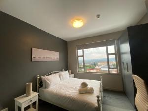 a bedroom with a bed and a large window at Luxurious 2 Bed @ The Tyrwhitt in Johannesburg