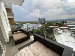 a balcony with a bed and a view of a city at Luxurious 2 Bed @ The Tyrwhitt in Johannesburg