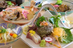 una mesa con varios platos de comida. en Kunibiki, en Izumo