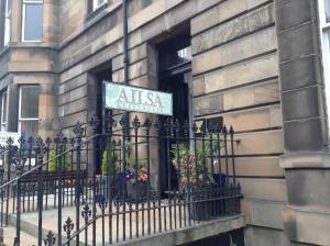 un cartel en un edificio con una valla en Ailsa Guest House, en Edimburgo