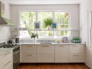 a white kitchen with a sink and a window at Cabana House at Casa Zoe in Charleston