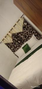 MeenangadiにあるDream inn family homestayのベッド1台(白黒の毛布、枕付)