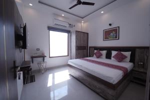 a bedroom with a large bed with a window at The Oscar Grand in Lucknow