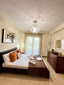 a bedroom with a large bed and a chandelier at Endless Blue Garden Villa in Paleo Tsifliki