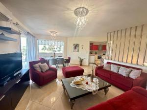 a living room with red couches and a table at Endless Blue Garden Villa in Paleo Tsifliki