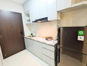a small kitchen with a stainless steel refrigerator at Lovina 19-16 at Formosa Residence in Jodoh