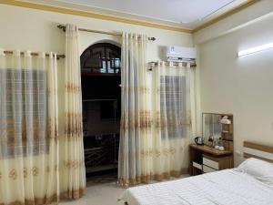 1 dormitorio con 1 cama y una ventana con cortinas en Nhà Nghỉ Hương Sen en Móng Cái