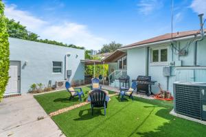 a yard with chairs and a grill and a house at Chic Downtown Home 42 And Guest Home 11 in West Palm Beach