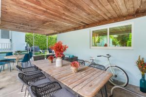 a wooden table with chairs and a bike on a patio at Chic Downtown Home 42 And Guest Home 11 in West Palm Beach