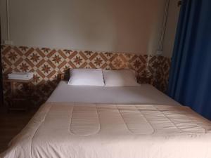 a bed in a bedroom with a blue curtain at Noppakao Resort in Soem Ngam