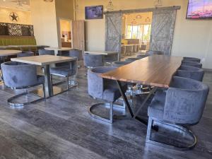 a dining room with tables and chairs and a tv at Wyndham Garden College Station in College Station