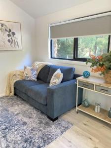 ein blaues Sofa im Wohnzimmer mit Fenster in der Unterkunft Marysville Holiday Park in Marysville