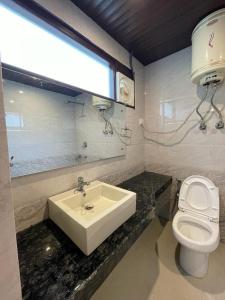 a bathroom with a sink and a toilet at ROYAL HILLS in Manāli