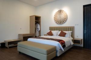 sypialnia z dużym łóżkiem i zegarem na ścianie w obiekcie Morika Villa w mieście Rua