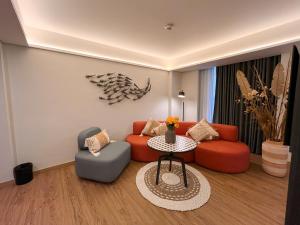 uma sala de estar com um sofá e duas cadeiras e uma mesa em Luminor Hotel Legian Seminyak - Bali em Seminyak