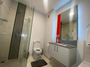 uma casa de banho com um WC e uma cabina de duche em vidro. em Stunning 1 Bedroom at The Median em Joanesburgo