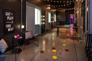 a living room with chairs and a table and a chalkboard at Moxy Portland Downtown in Portland