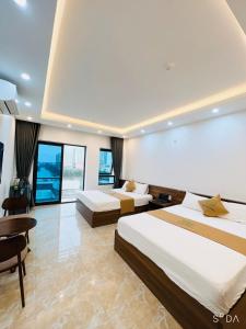Habitación de hotel con 2 camas, mesa y sillas en THE SUN HOTEL và VILLA FLC en Lôc Hải