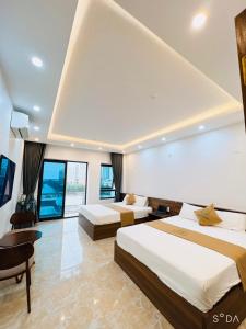 Habitación de hotel con 2 camas y escritorio en THE SUN HOTEL và VILLA FLC en Lôc Hải