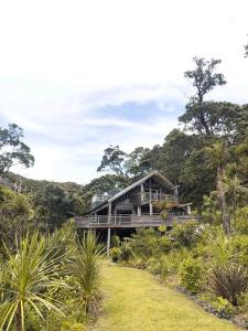 a house in the middle of a forest at Whananaki Hideaway 