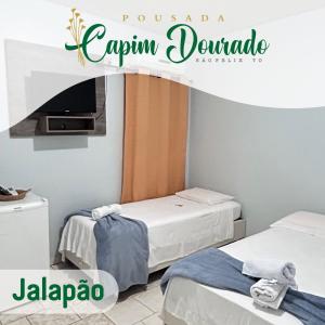 Cette chambre comprend 2 lits et une télévision. dans l'établissement Pousada Capim Dourado Jalapão São Felix TO, à São Félix do Tocantins