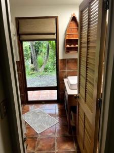 a bathroom with a sink and a door with a window at Whananaki Hideaway 