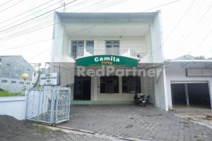 - un bâtiment blanc avec un panneau vert dans l'établissement Camila Living Yogyakarta RedPartner, à Timuran