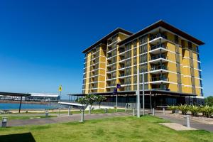 a large yellow building next to a body of water at Serenity Deja Blue - at Darwin Waterfront in Darwin