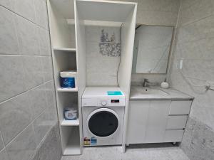 a bathroom with a washing machine and a sink at Relax in Chipping Norton Entire Home 3 bedrooms in Chipping Norton
