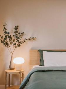 een slaapkamer met een bed en een vaas met een plant bij Tranquil Japandi Retreat: Cozy Oasis in New Westminster