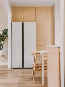 een keuken met witte kasten, een tafel en een koelkast bij Tranquil Japandi Retreat: Cozy Oasis in New Westminster