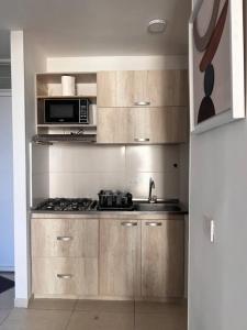 a kitchen with a stove and a microwave at Apartamento lujoso en Valledupar in Valledupar