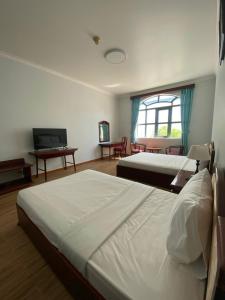 Un pat sau paturi într-o cameră la NGOC THU HOTEL