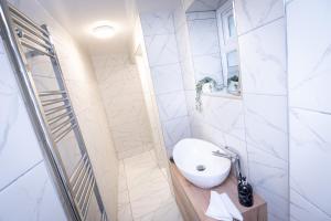 a white bathroom with a sink and a mirror at Kings Arms Suites - Luxury Double - Waterfall Shower - Self Check In in Whitehaven