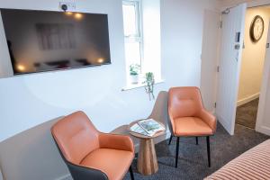 a waiting room with two chairs and a tv at Kings Arms Suites - Luxury Double - Waterfall Shower - Self Check In in Whitehaven