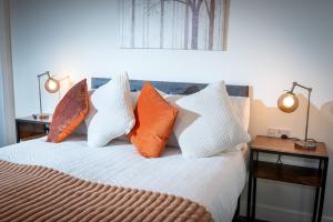 a bedroom with a bed with orange and white pillows at Kings Arms Suites - Luxury Double - Waterfall Shower - Self Check In in Whitehaven
