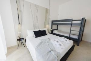 1 dormitorio con 1 cama con sábanas blancas y 1 litera en Salentin Home - SeaRelax, en San Pietro in Bevagna