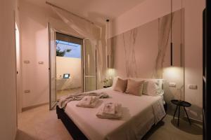 1 dormitorio con 1 cama grande y toallas. en Salentin Home - SeaRelax, en San Pietro in Bevagna